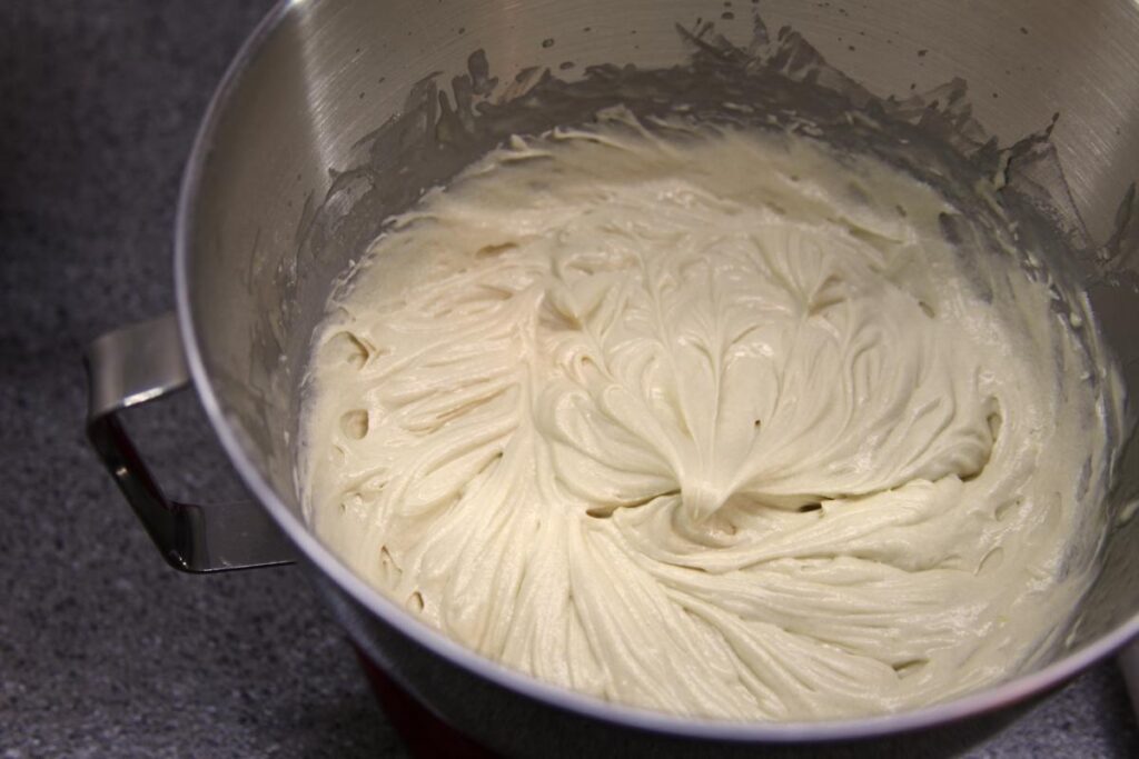 Madeleine batter after the addition of butter. The batter is thick and the whisk has left marks in the batter from its passage.