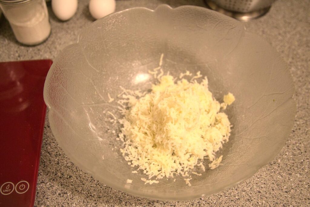 A large bowl with a mound of finely grated potato in the bottom.