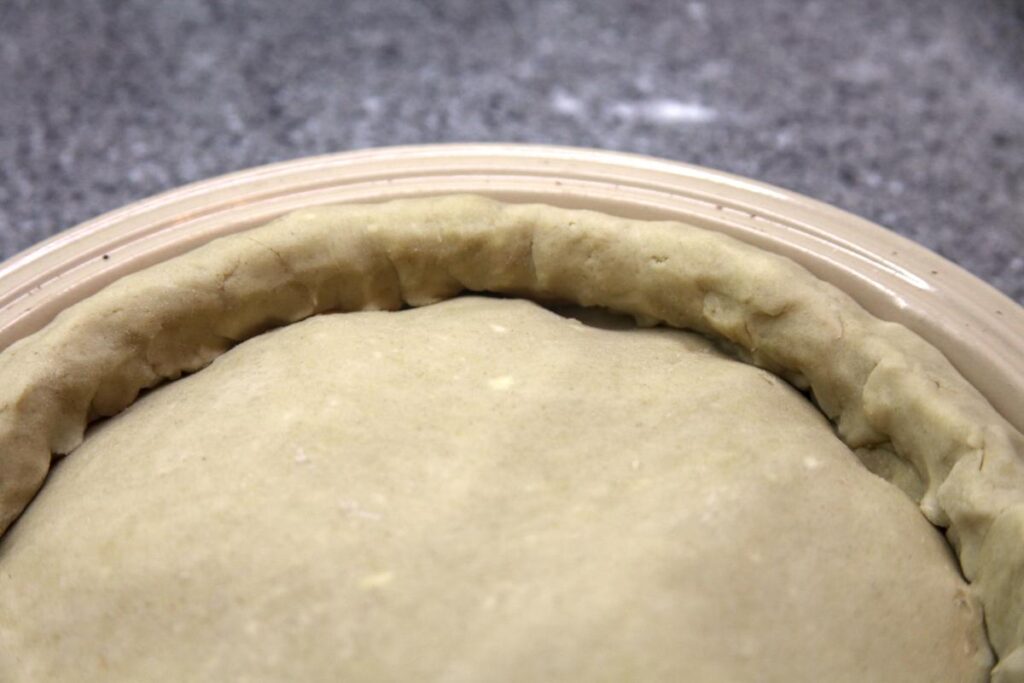 A close-up of the edge of a pie with the edges completely rolled up.